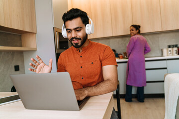 Young indian man using laptop while spending time with hisgirlfriend