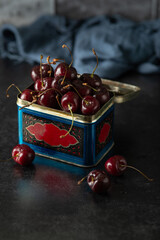 Fresh organic cherries in a tin box on a dark background. Close up - 622676084