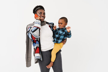 Black woman talking on cellphone while holding with her son