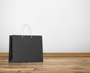 black paper bag in room white walls and wooden floor