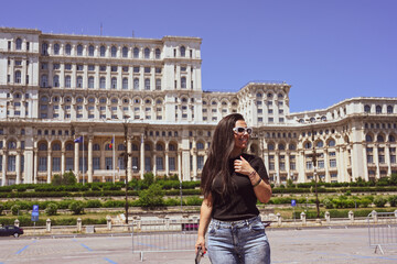  Bucharest ,Romania Constitution Square.  Young beautiful smiling  woman  using a mobile phone...