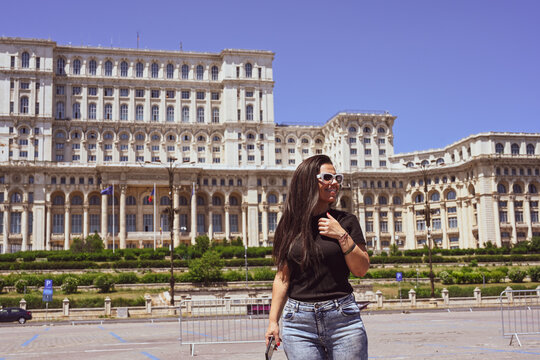   Bucharest ,Romania Constitution Square.  Young beautiful smiling  woman  using a mobile phone taking a pictures.Concept of Romanian gastronomy and trave