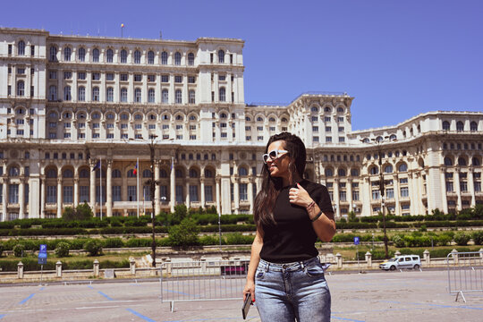   Bucharest ,Romania Constitution Square.  Young beautiful smiling  woman  using a mobile phone taking a pictures.Concept of Romanian gastronomy and trave