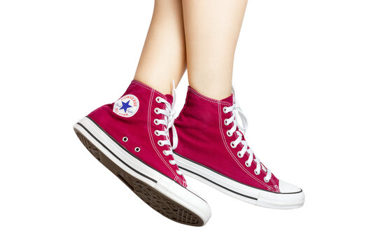 UKRAINE, DNEPR - JUNE 23, 2023: Red Converse All Star sneakers on women's feet