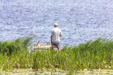 Fisherman on the bank of the river with fishing rods. Fishing rods. Fishing from the pier. A quiet hobby. Summer fishing. Outdoor activity.