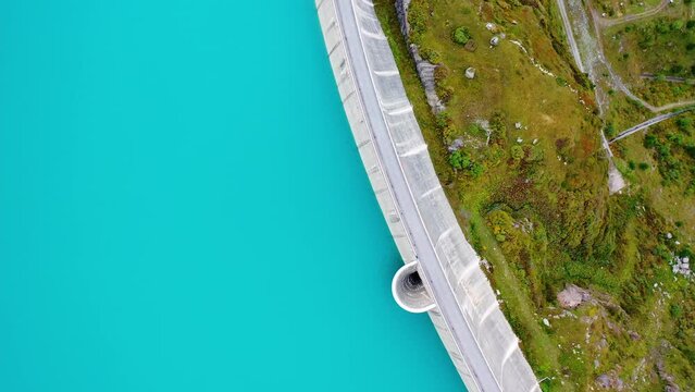 Moiry, Switzerland: Aerial overhead drone footage of the Moiry dam above the Grimentz village in the Anniviers valley in Canton Valais in the Swiss alps in summer with turquoise water