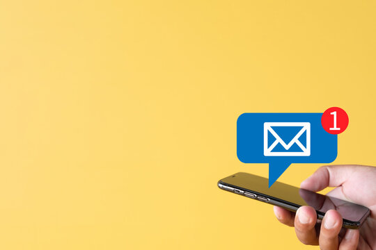 Reminder,Email,incoming message,Business concept.,Hand holding smartphone with Email Notification icon on yellow background with copyspace suitable for e-mail,technology,Internet idea.