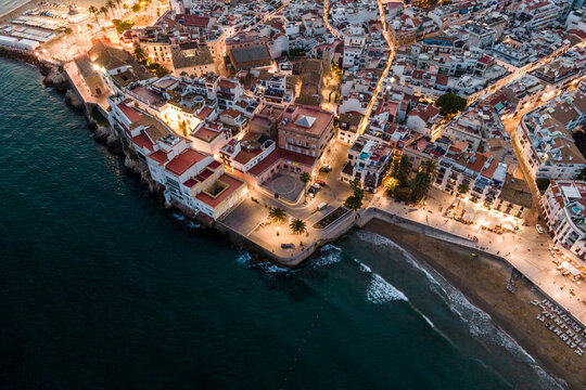 Aerial view of Sitges downtown along the Mediterranean Sea coastline at sunset, Barcelona, Spain.