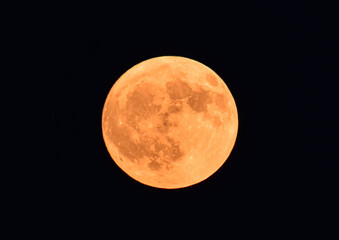 black night sky and strawberry red orange moon in detail close up