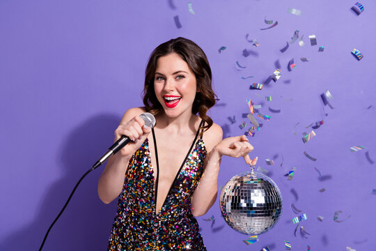 Photo of charming vogue stylish lady hold shiny disco ball mic night club host emcee wear overall isolated purple color background
