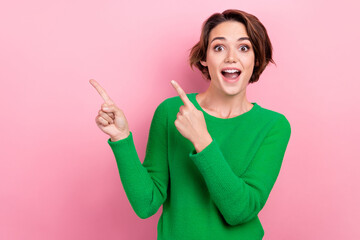 Photo of young surprised girl wear green jumper shocked impressed reaction indicate fingers empty space isolated on pink color background - obrazy, fototapety, plakaty