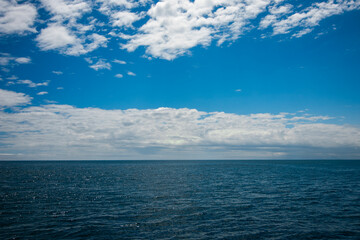 Paisagem do mar ao céu azul e montanhas.