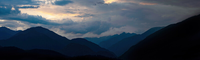 Mountain landscape view panorama background - Sunrise or sunset with silhouette of mountains alps, cloudy sky