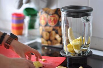 Making a banana smoothie and cutting fruits in the kitchen