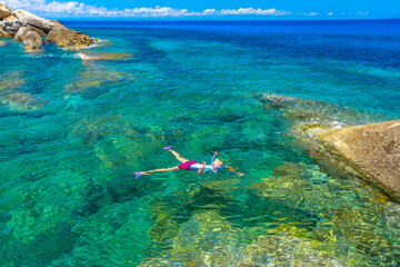 woman snorkeling in Sant 'Andrea beach and Cote Piane side in Elba island. Tourist woman in clear waters of Tyrrhenian sea on holiday travel in Italy. Saint Andrew is popular seaside resort.