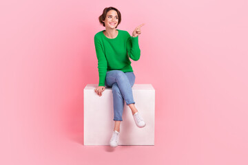 Full length size photo of attractive advertise marketer sitting white podium direct finger mockup novelty isolated on pink color background