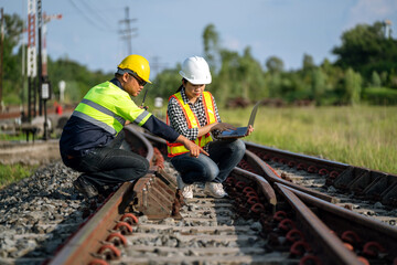 Architects and engineers are pointing at the railway track where the repair process of the railway switchgear construction has to be accelerated and inspection work in the station.
