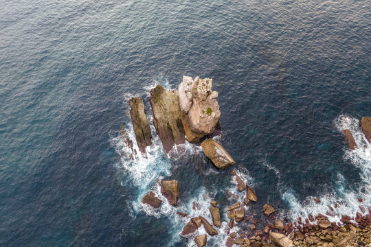 Aerial view of rocks along the cliffs in Cabo Carvoeiro along the Atlantic Ocean coastline in Peniche, Leiria, Portugal.