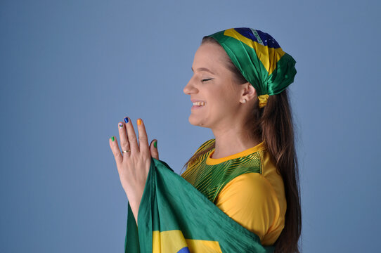 bela jovem brasileira com cores da bandeira do brasil fazendo oração , brasil nação verde e amarela 