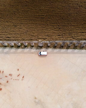Aerial view of a camper van parking in a parking lot in Obidos near the agricultural fields, Portugal.