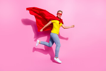Full length photo of excited cheerful person wear red superhero costume jumping running isolated on pink color background