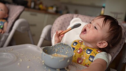 baby dirty eats. happy family toddler concept. baby girl learns to eat with her hands dirty her face dirty funny video dirty. baby on dream the table for feeding eats with her hands from a cup