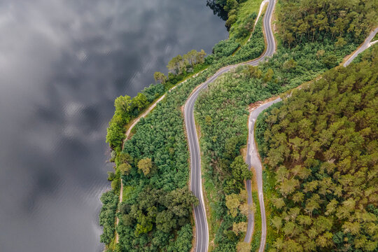Aerial view of a road driving along the coast of Minho river in Val de Pereira, Ourense, Spain.
