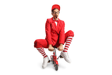 Funny entertainer riding a small red bike
