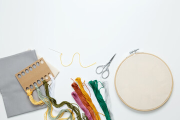 Embroidery set fot stitching. Beige cotton cloth in embroidery hoop on white background with...