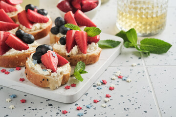 American flag sandwich with strawberries, blueberries, whipped sweet cream, soft cheese on toast bread. 4th of July American Independence Day food. Independence or Patriotic Day breakfast idea Mock up