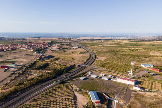 Aerial view of the highway crossing a wind farm with many wind turbines, La Muela, Zaragoza, Spain.