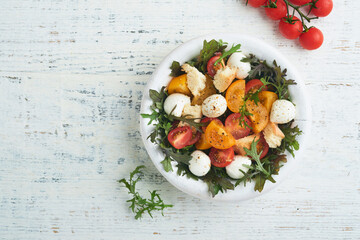Tuscan Panzanella. Cherry Tomatoes salad with arugula, basil, mozzarella and bread crackers on white bowl. Traditional italian salad. Mediterranean healthy food and cuisine.