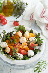 Tuscan Panzanella. Cherry Tomatoes salad with arugula, basil, mozzarella and bread crackers on white bowl. Traditional italian salad. Mediterranean healthy food and cuisine.