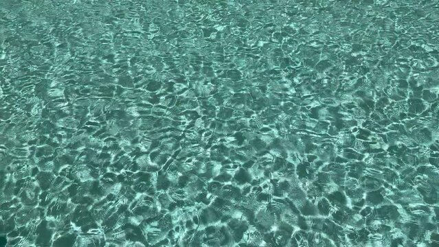 Turquoise waves of water in swimming pool. Summer water pool background. Slow motion