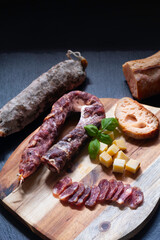 Food concept organic bio Saucisson French  dry-cured salamis or sausages on black slate stone background with copy space