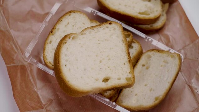 Sliced gluten-free lactose-free diet bread in a plastic pack close-up. Falling slice in slow motion
