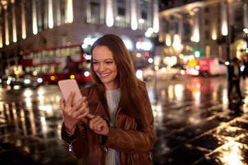 Young woman using a smart phone while walking in the city london