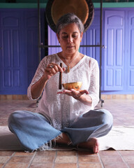 Abuela haciendo terapia alternativa con felicidad, cuenco tibetano