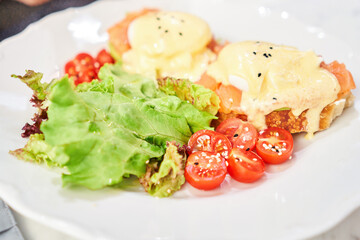 Brioche, poached egg, avocado cream with salmon and egg . Healthy breakfast, protein. Restaurant dish. 