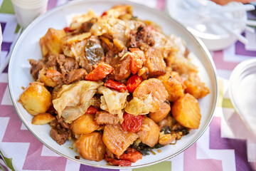 Dimlama - stewed vegetables with the meat in a large Central Asian cauldron. Uzbek cuisine. Fried vegetables with meat. Outdoor lunch, picnic