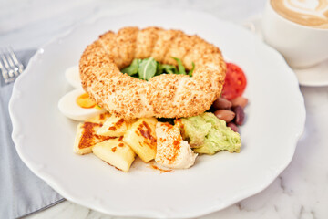 Turkish breakfast with simit, cheese, tomato, cucumber, olives. Breakfast with coffee in the restaurant. Morning nutritious meal