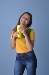 jovem mulher brasileira com camisa do brasil tomando suco ou água , vida saudável 