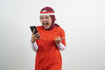 Hijab Woman screaming holding phone, indonesian independence day