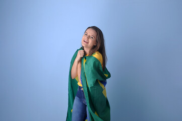 mulher brasileira segurando bandeira do brasil em fundo azul, celebração da nação brasileira 