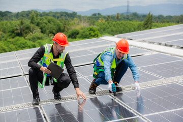 Technician engineer planning to setting solar panel on the roof of the building to work at full efficiency, Using solar cells for energy saving to save and protect environment. Renewable energy