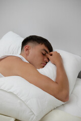 Fototapeta na wymiar Young Man Laying In Bed