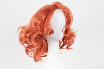 Natural looking ginger wig on white mannequin head. Medium length hair with wavy curls on the...