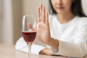 Alcoholism, depressed asian young woman hand refuse red wine or alcoholic beverage, female drinking...