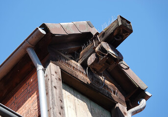 The ridge of an ancient house with a pulley to hoist things up. Everything is secured against pigeons with pins.