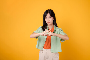 portrait young asian 30s woman expression serious negative face and showing cross finger deny hand gesture isolated on yellow background. wrong, no, stop and rejection body sign symbol concept